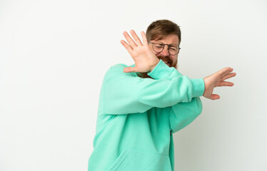 Young reddish caucasian man isolated on white background nervous stretching hands to the front