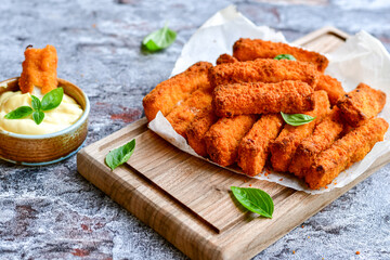 Close up of   Crispy breaded  deep fried fish fingers with breadcrumbs served  with remoulade sauce...