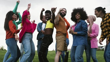 Young multiracial friends having fun dancing together in park - Friendship and diversity concept