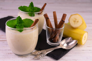 Banana dessert with cinnamon in a glass. Banana parfait on a wooden background.