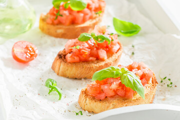 Fresh and hot bruschetta with basil and tomatoes as snack.