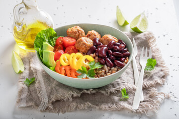 Spicy Mexican salad with groats, meatballs, limes and vegetables.