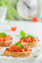 Crisp and healthy bruschetta with tomato and herbs as snack.