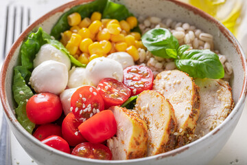 Colorful Caesar salad with cheese, chicken and groats.