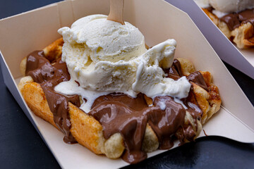 Yummy crispy belgian waffle with chocolate and vanilla ice cream on top