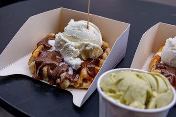 Yummy crispy belgian waffle with chocolate and vanilla ice cream on top