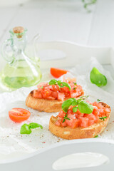 Tasty and fresh bruschetta with basil and tomatoes as snack.
