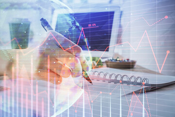 Financial forex graph drawn over hands taking notes background. Concept of research. Multi exposure