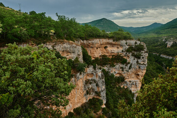 Young woman observing the Ebro river bed under a yellow umbrella on a stormy afternoon