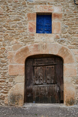 Fototapeta na wymiar Stone facade with ancient wooden door in Pesquera de Ebro