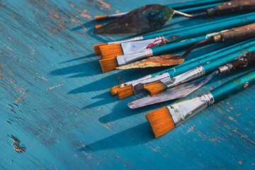 Paint brushes with palette knives on blue background
