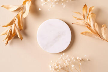 Dry natural grass, leaves and flowers with white marble podium beauty and fashion concept mock up
