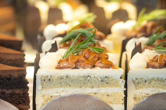 A sliced piece of almond nut vanilla butter cake selling at the sweet cafe shop. ฺBakery food object, close-up photo.