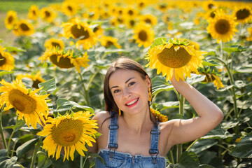 Sexy Ukrainian model girl in a field with sunflowers on a sunny day