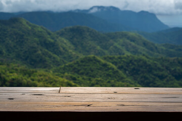 Empty wooden counter table space with greenery mountain as background.