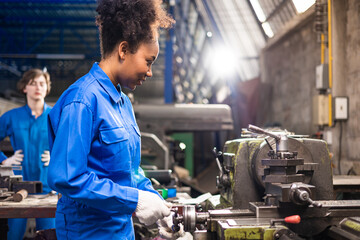 African American Young woman worker  in protective uniform operating machine at factory Industrial.People working in industry.Portrait of Female  Engineer at work place.