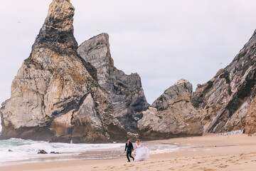 sand and cliffs on the coast of sea. newlyweds having fun and ru