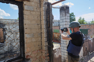 War correspondent photographs destroyed buildings after the bombing in Ukraine. War in Ukraine.