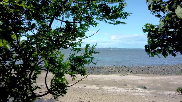 Midlothian, Scotland &ndash; June 19 2022. A panning shot of the Firth of the Forth (Linne Foirthe) captured from Cramond promenade on a bright and sunny day