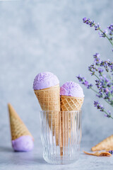 Creamy vegan lavender ice cream in the horn in a glass with lavender flowers. Summer seasonal cold sweet healthy vegan dessert