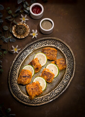 BBQ fish tikka boti kabab with sauce served in dish isolated on dark background top view