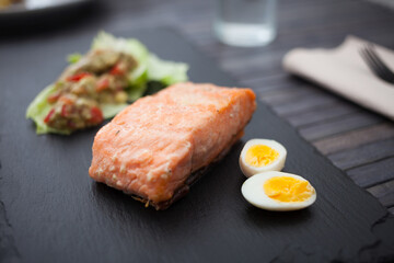 baked salmon fillet with homemade guacamole and quail eggs halves