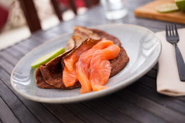 salted salmon fillet with buckwheat pancakes and lime
