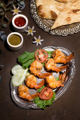 Grilled Jumbo Prawn platter with mint sauce served in dish isolated on dark background top view