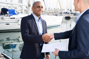 two men in suits buy and sell a yacht in the seaport