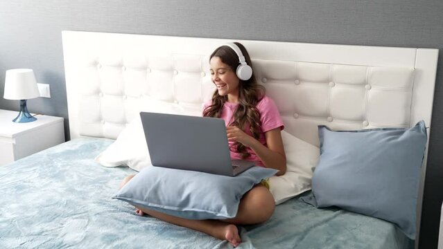 laughing child in headphones having online video call using computer, good mood