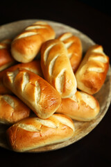 Fresh small buns on a wooden tray.