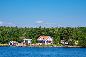 Fototapeta na wymiar Ostseeküste mit Bäumen und Häusern nahe der Insel Uvö in Schweden