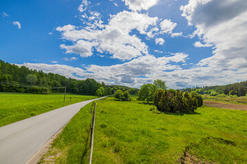 Beautiful view of road and green forests with river merging with blue sky on horizon. Sweden.