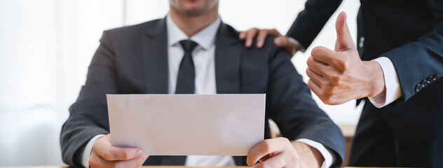 Close up view of boss giving commission bonus to office worker.