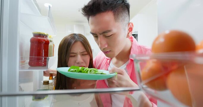 asian couple open refrigerator