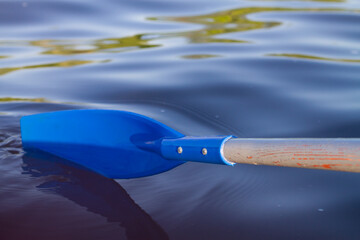 The blue paddle from the boat was rowing the water © Olga