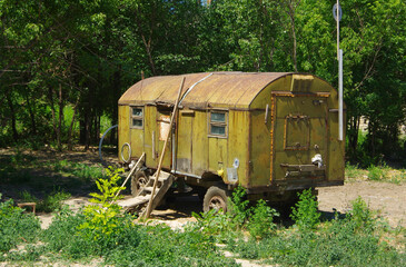 Old metal wagon covered with old peeling and cracked green paint.