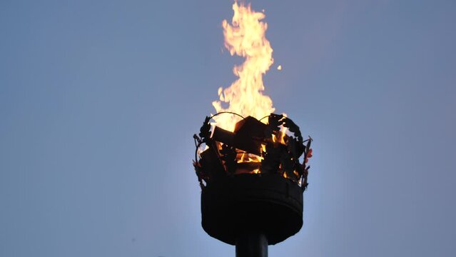 Crown on a pillar with fire. Close-up of a fire on a pole. A cinematographic picture. Soft focus on objects. Pagan bonfire festival in Latvia Summer night Ligo. Midsummer bonfire on a pole.