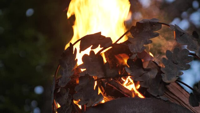 Crown on a pillar with fire. Close-up of a fire on a pole. A cinematographic picture. Soft focus on objects. Pagan bonfire festival in Latvia Summer night Ligo. Midsummer bonfire on a pole.