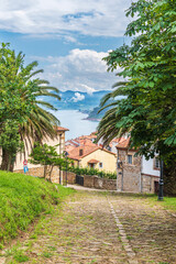 Fototapeta na wymiar Cobbled street in the upper part of the town of Lastres with the Cantabrian Sea in the background, Asturias.