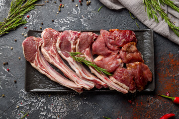 raw lamb on dark plate, rack of lamb and lamb meat top view