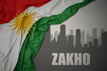 abstract silhouette of the city with text Zakho near waving national flag of kurdistan on a gray...