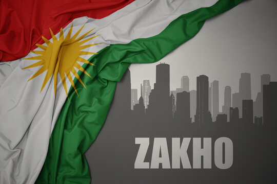 abstract silhouette of the city with text Zakho near waving national flag of kurdistan on a gray background.3D illustration