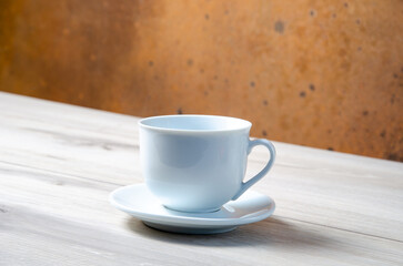 Cup of coffee with coffee beans on a wooden table. White cup with espresso coffee. Background for a coffee shop. Arabica.