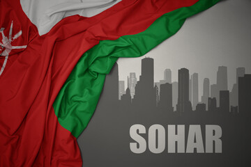 abstract silhouette of the city with text Sohar near waving national flag of oman on a gray background.3D illustration