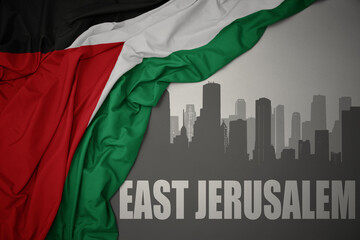 abstract silhouette of the city with text East Jerusalem near waving national flag of palestine on...
