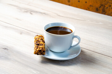 Cup of coffee with coffee beans on a wooden table. White cup with espresso coffee. Background for a coffee shop. Arabica.