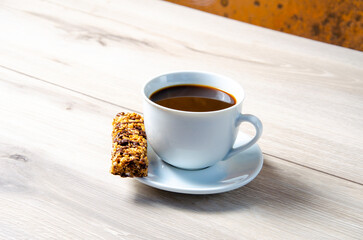 Cup of coffee with coffee beans on a wooden table. White cup with espresso coffee. Background for a coffee shop. Arabica.