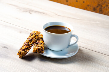 Cup of coffee with coffee beans on a wooden table. White cup with espresso coffee. Background for a coffee shop. Arabica.
