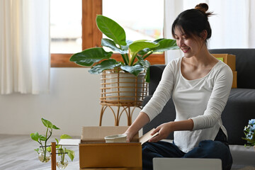 Fototapeta na wymiar Young small business owner packing vase in the box at home office, Prepare product for packaging process, Online selling, Internet marketing, E-commerce concept.